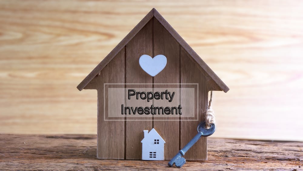 Wooden house with investment sign